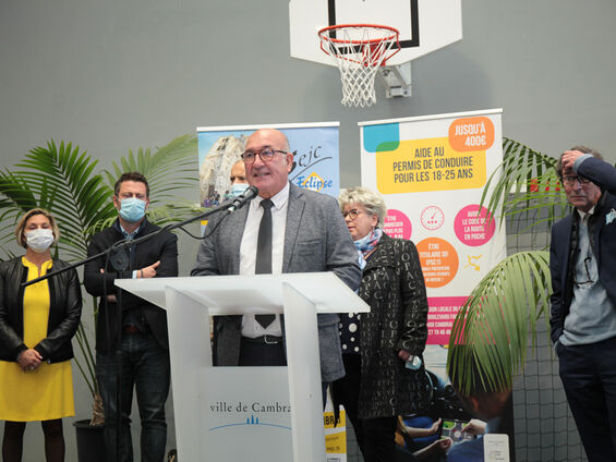 Discours Mr DESTOMBES devant pupitre blanc et en arrière plan les élus.