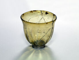 Gobelet ovoïde en verre soufflé à la volée, VI – VIIème siècles, Nécropole mérovingienne de Les-Rues-des-Vignes, sépulture masculine en pleine terre, tombe L9, inv. 1983-RDV-256