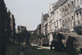 Défilé de camions militaires avec remorque, remplis de soldats armés avançant en direction l’arrière de la Porte Notre Dame venant de la rue d'Alger.