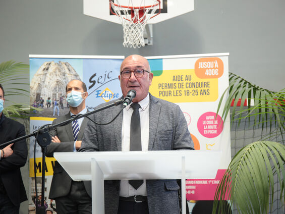 Discours Mr DESTOMBES devant pupitre blanc et en arrière plan les élus.
