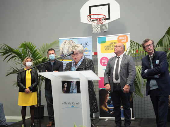 Discours de Mme Lydie Librizzi, présidente de la caisse d'allocations familiales du Nord (CAF) devant un pupitre blanc en arrière plan Mr Le maire F-X VILLAIN et les élus de la ville de CAMBRAI