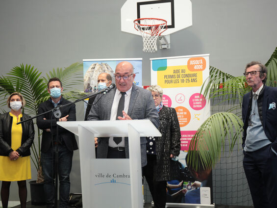 Discours Mr DESTOMBES devant pupitre blanc et en arrière plan les élus.