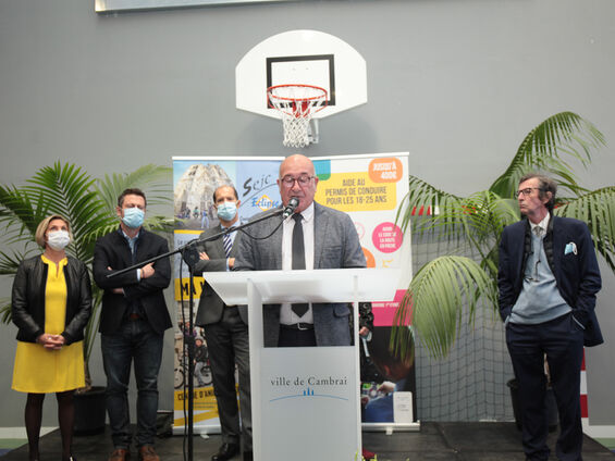 Discours Mr DESTOMBES devant pupitre blanc et en arrière plan les élus.
