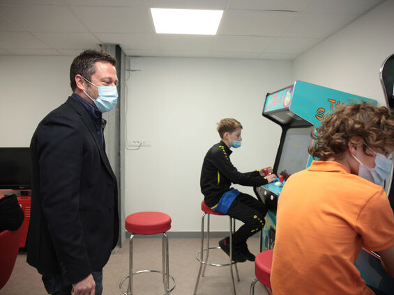 Mr Siegler observant deux jeunes jouant au jeu d'arcade