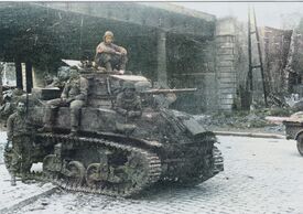 4 soldats assis sur le Char américain et un soldat à coté de l'arrière du char arrêté, prêt du Pont de l'avenue Albert Ier