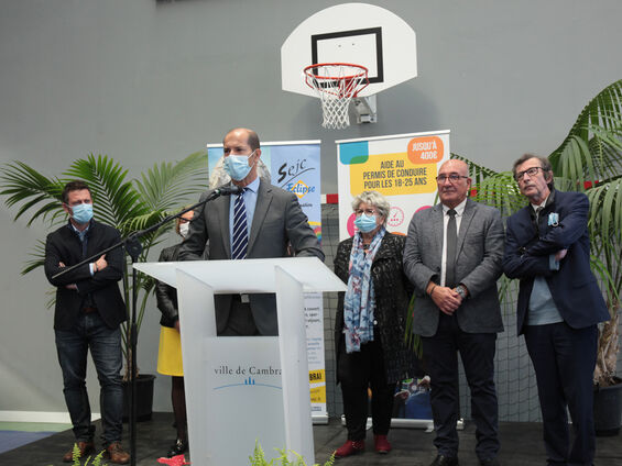 Discours Sous-préfet Raymond Yeddou devant pupitre blanc et en arrière plan les élus.