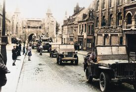 Défilé de Jeep et de chars partant de la porte de Paris vers le centre ville