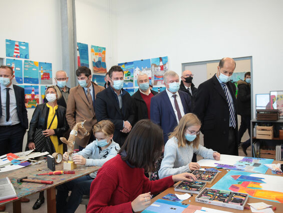Les élus observent des jeunes lors d'un atelier d'arts plastiques.
