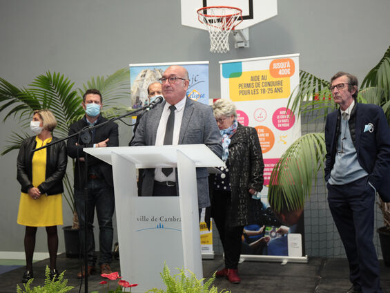 Discours Mr DESTOMBES devant pupitre blanc et en arrière plan les élus.