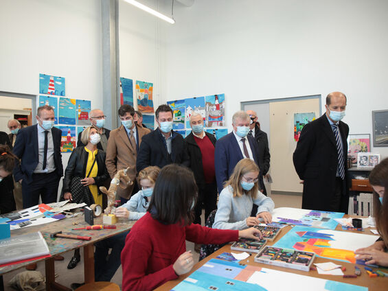 Les élus observent des jeunes lors d'un atelier d'arts plastiques.