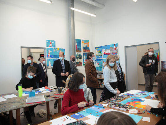 Les élus observent des jeunes lors d'un atelier d'arts plastiques.