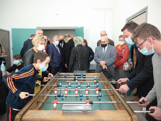 Les élus observent des jeunes jouant au baby-foot.